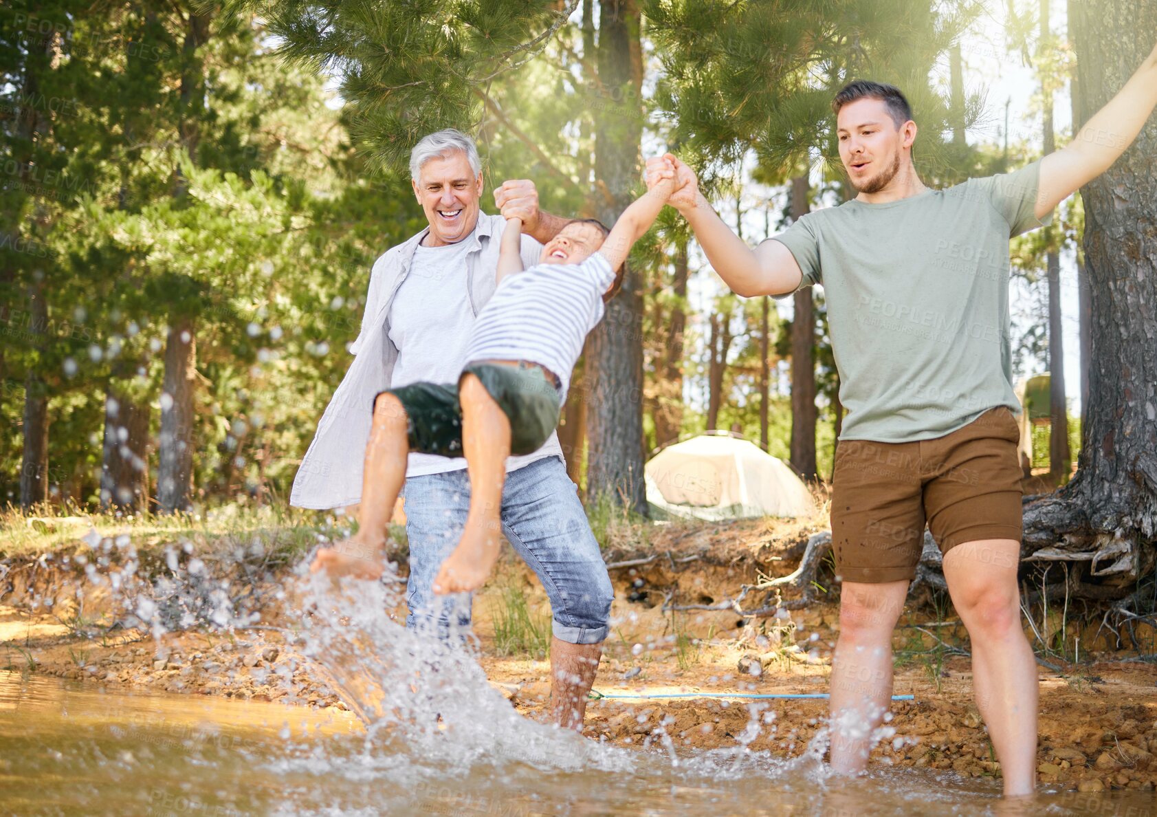 Buy stock photo Hiking, grandfather and dad swinging a boy with a water splash in the forest while on a camping trip together. Children, adventure and a family walking over a river while in the woods or wilderness