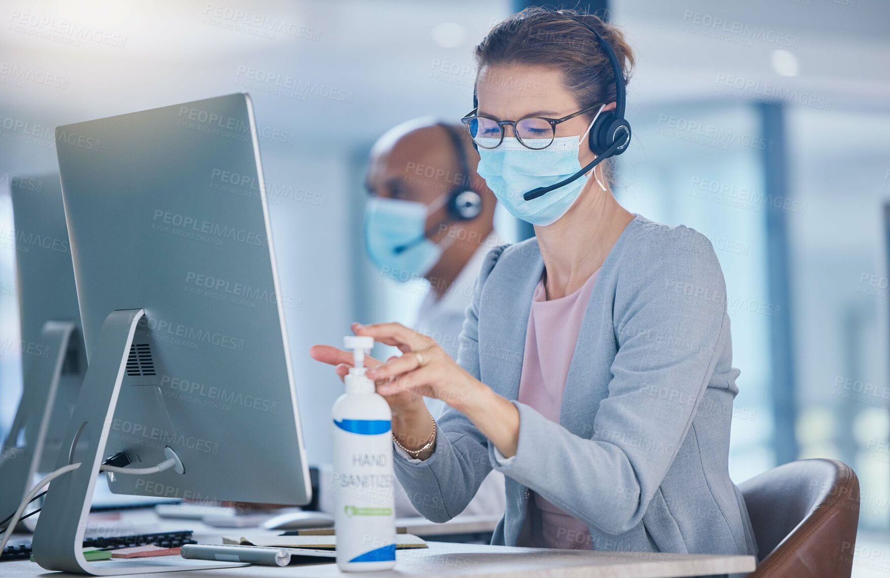 Buy stock photo Sanitize, hygiene and compliance with covid19 regulations at  call center with crm agent cleaning workstation. Woman working in customer service, making sure to leave desk fresh for the next operator