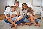 Big family, happy and smile with quality time at home in a bedroom with children. Happiness of mother, man and kids laughing at a funny joke on the house floor together with joy and parent love