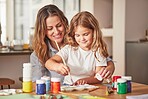 Mother, girl and painting art in house studio, home or creative space with brush, oil paint or palette. Happy smile mom, child or kid bonding in relax design or class activity for adhd or autism help