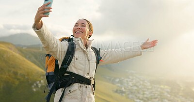 Woman, trekking on mountains and selfie or video call for hiking, adventure and eco friendly blog on social media. Vlogger or influencer with live stream, travel or journey on a hill, rock and nature