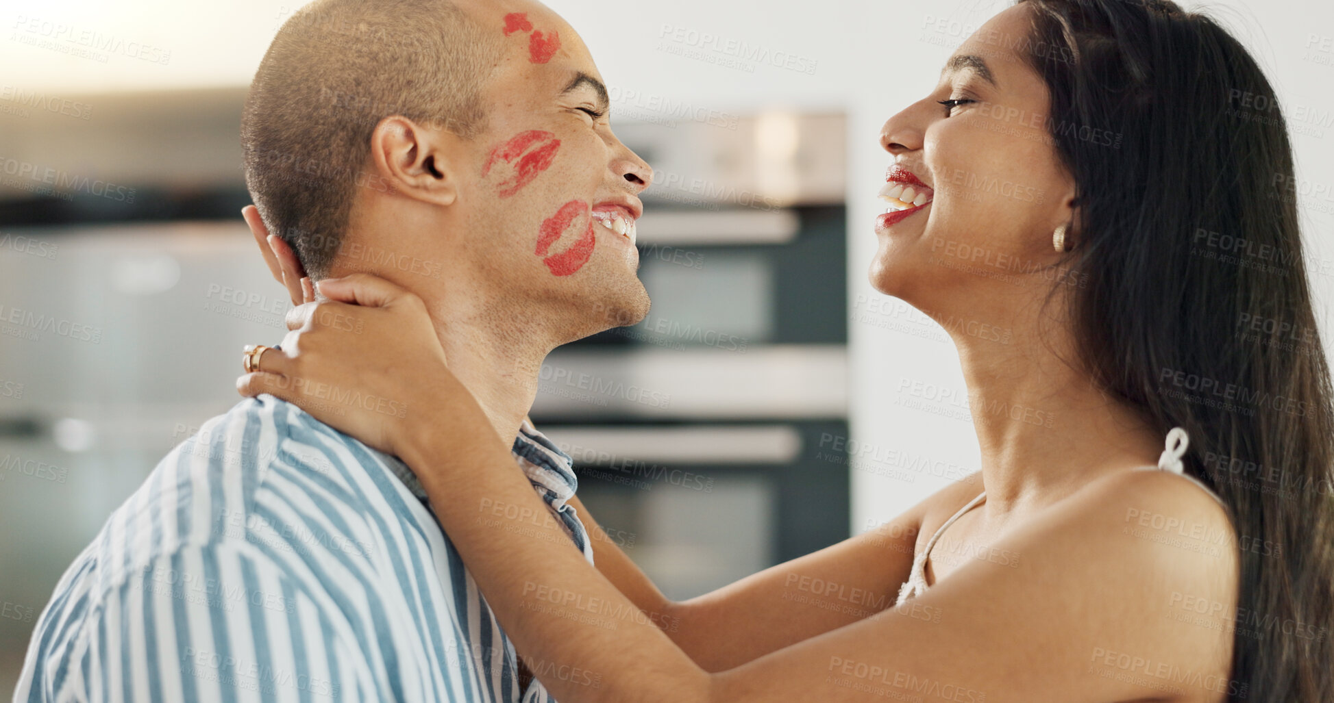 Buy stock photo Happy couple, love and kiss with lipstick for fun date and playful at home in intimacy, romance and valentines day. Lover, woman and man in kitchen or house with lip print on cheek for anniversary