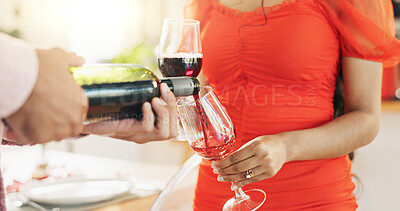 Couple, hands and pour red wine for celebration of love, romance and valentines day on anniversary. People closeup on date with champagne bottle, glasses and drinks for toast, success and luxury