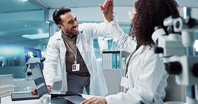Scientist, teamwork and high five with laptop in laboratory for test breakthrough, pharmaceutical review or success. Science, collaboration or technology for research, discussion and digital analysis