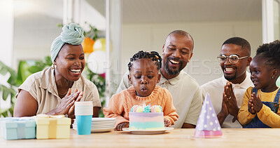 Birthday, kids party and applause with a black family in celebration of a girl child in their home. Parents, grandparents and children clapping while blowing candles on a cake at a milestone event