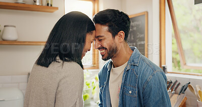 Love, hug and happy couple in a kitchen talking, together and intimate while bonding in their home. Embrace, romance and man with woman hugging, smile and sharing moment, conversation and laughing