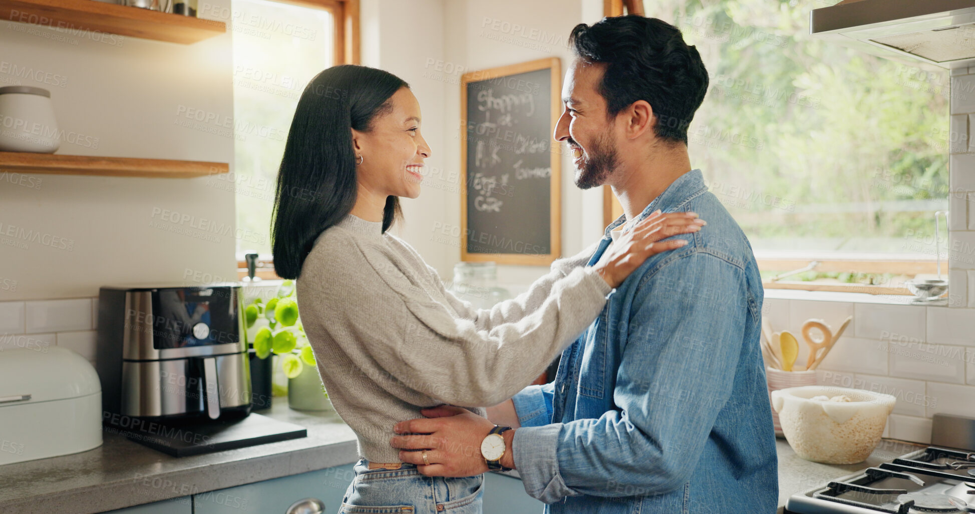 Buy stock photo Hug, happy and couple in a kitchen bonding, intimate and talking in their home together with intimacy. Love, face and woman embrace man with smile, care and sharing romantic moment and conversation