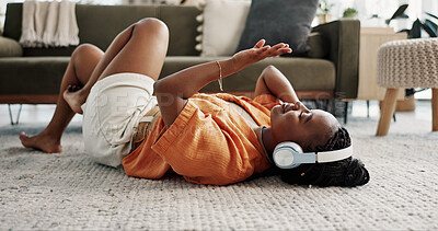 Music, headphones and black woman on floor, listening to song and audio in living room. Happy African person on radio, streaming sound and technology for freedom, relax on carpet and smile in home