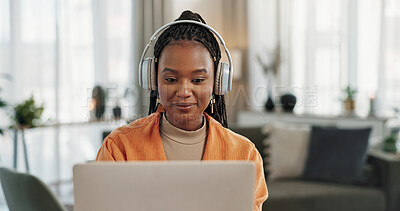 Laptop, headphones and young woman in living room listening to music, playlist or album in modern apartment. Technology, smile and young African person streaming song on computer in lounge at home.