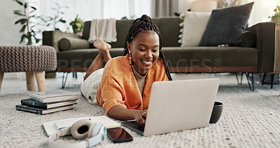 Laptop, smile and woman typing on the floor in the living room of modern apartment for research. Technology, happy and young African female university student studying on a computer in lounge at home