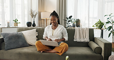 Black woman on sofa, smile and typing on laptop for remote work, social media or blog post research in home. Happy girl on couch with computer checking email, website or online chat in living room.