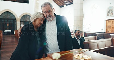 Funeral, coffin and senior couple hug in church for goodbye, mourning and grief in memorial service. Depression, sad family and man embrace woman by casket for greeting, loss and burial for death