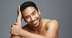 Face, cosmetics and Asian man with skincare, smile and dermatology on a grey studio background. Portrait, Japanese person and happy model with wellness, luxury treatment and beauty with aesthetic