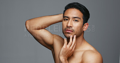 Face, cosmetics and Asian man with dermatology, shine and luxury treatment on a grey studio background. Portrait, Japanese person or model with wellness, glow and spa grooming with aesthetic and soft