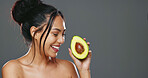 Woman, avocado and beauty in studio for health, diet or smile on face for skincare by background. Girl, model or happy for fruit, nutrition choice or vegan food for wellness, natural glow or portrait