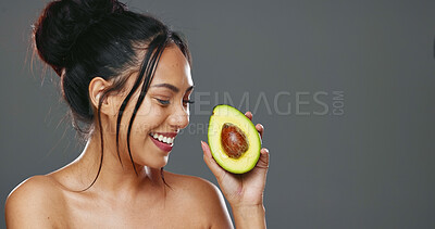 Woman, avocado and beauty in studio for health, diet or smile on face for skincare by background. Girl, model or happy for fruit, nutrition choice or vegan food for wellness, natural glow or portrait