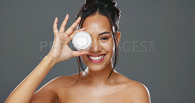 Happy woman, face and cream for skincare, beauty or cosmetics against a grey studio background. Portrait of female person smile with moisturizer, creme or lotion for facial treatment or product