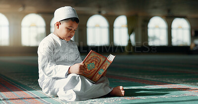 Islam, boy in mosque reading Quran for learning mindfulness and gratitude in faith with kids prayer. Worship, religion and Muslim student in holy temple praise with book, spiritual teaching and study