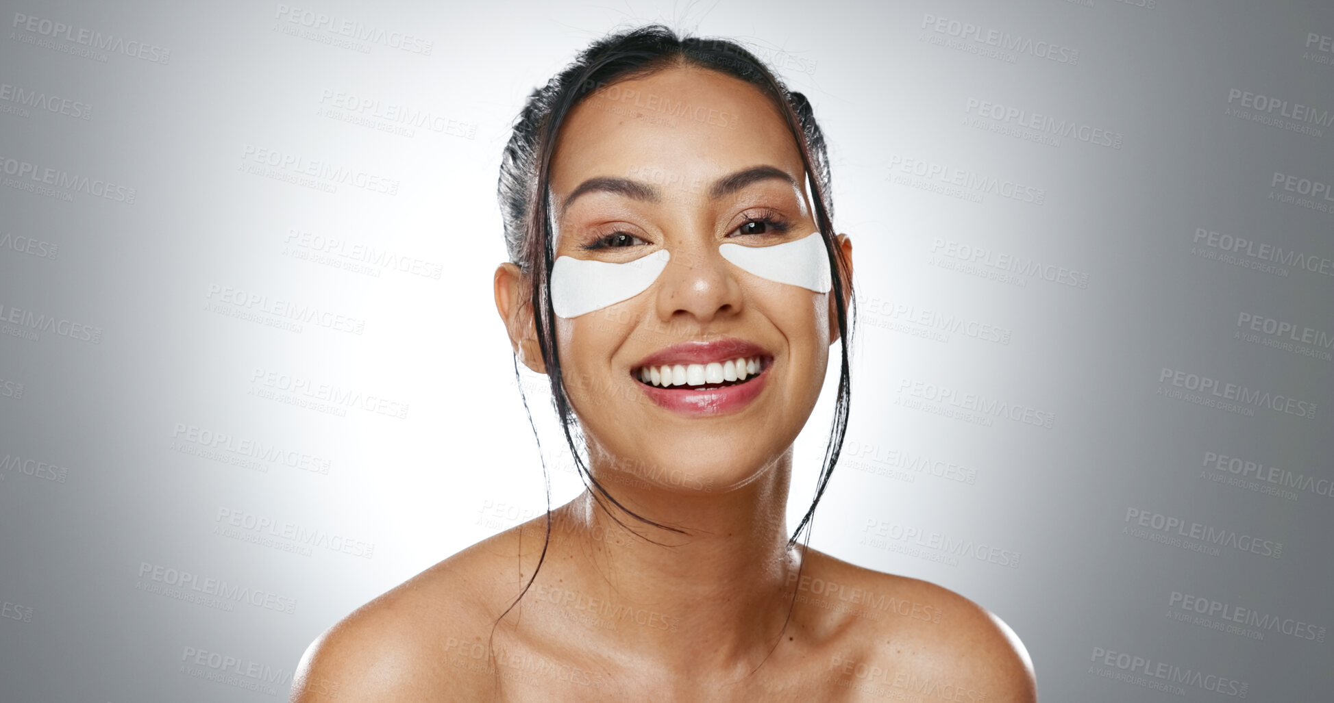 Buy stock photo Face, eye patches and woman with skincare, cosmetics and dermatology on a grey studio background. Portrait, person and model with beauty, treatment and healthy skin with grooming, smooth and shine