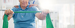 Resistance band, physical therapy and old man with physiotherapist, muscle training and strength with senior care. Health, wellness and people at physio clinic with rehabilitation and equipment