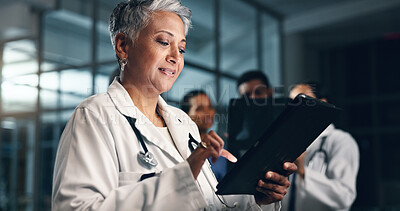 Doctor, mature woman and happy with tablet in night, typing or smile for results, meme or notification in hospital. Senior nurse, digital touchscreen or funny video with click, scroll or social media