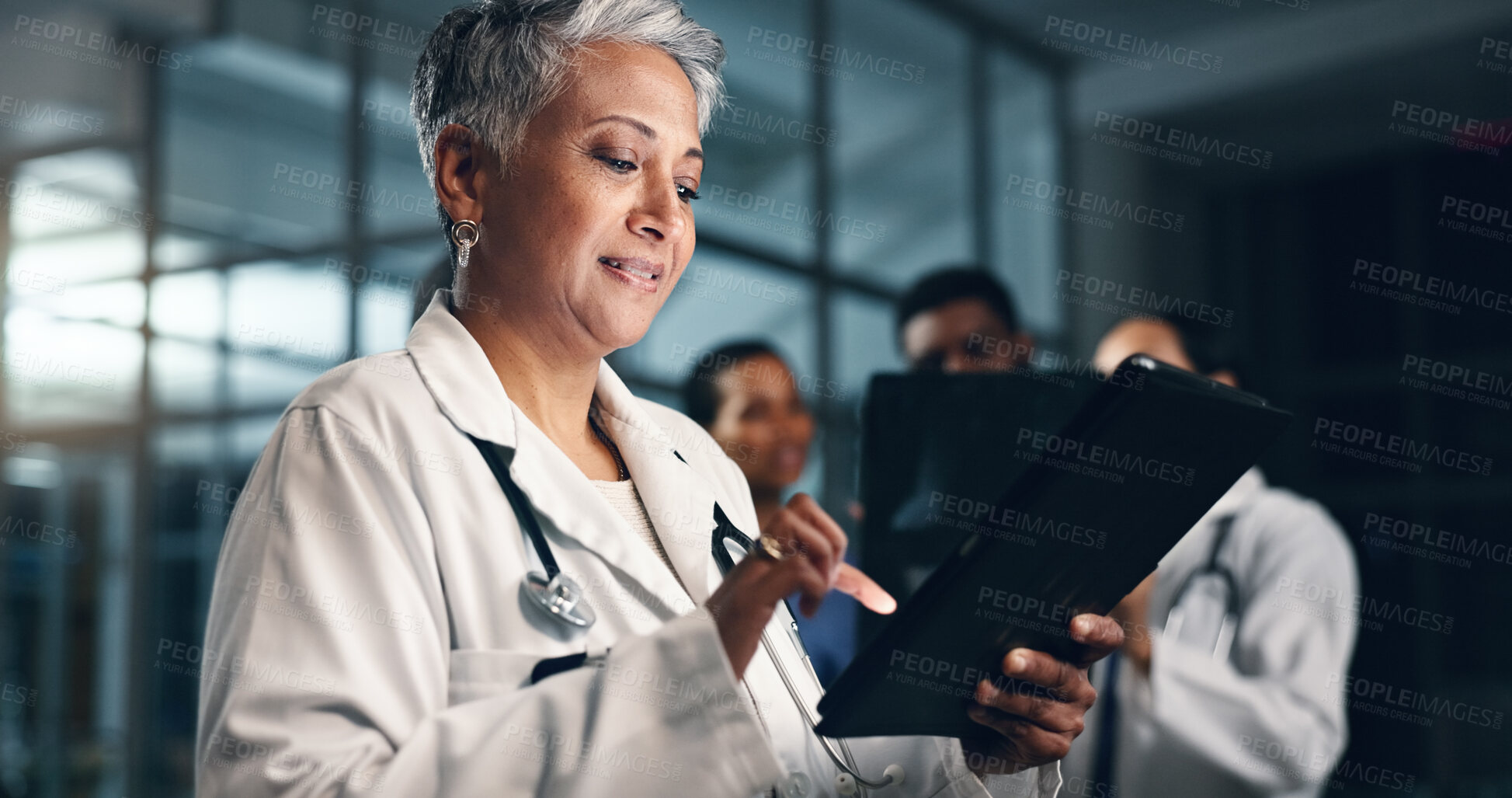 Buy stock photo Doctor, mature woman and happy with tablet in night, typing or smile for results, meme or notification in hospital. Senior nurse, digital touchscreen or funny video with click, scroll or social media