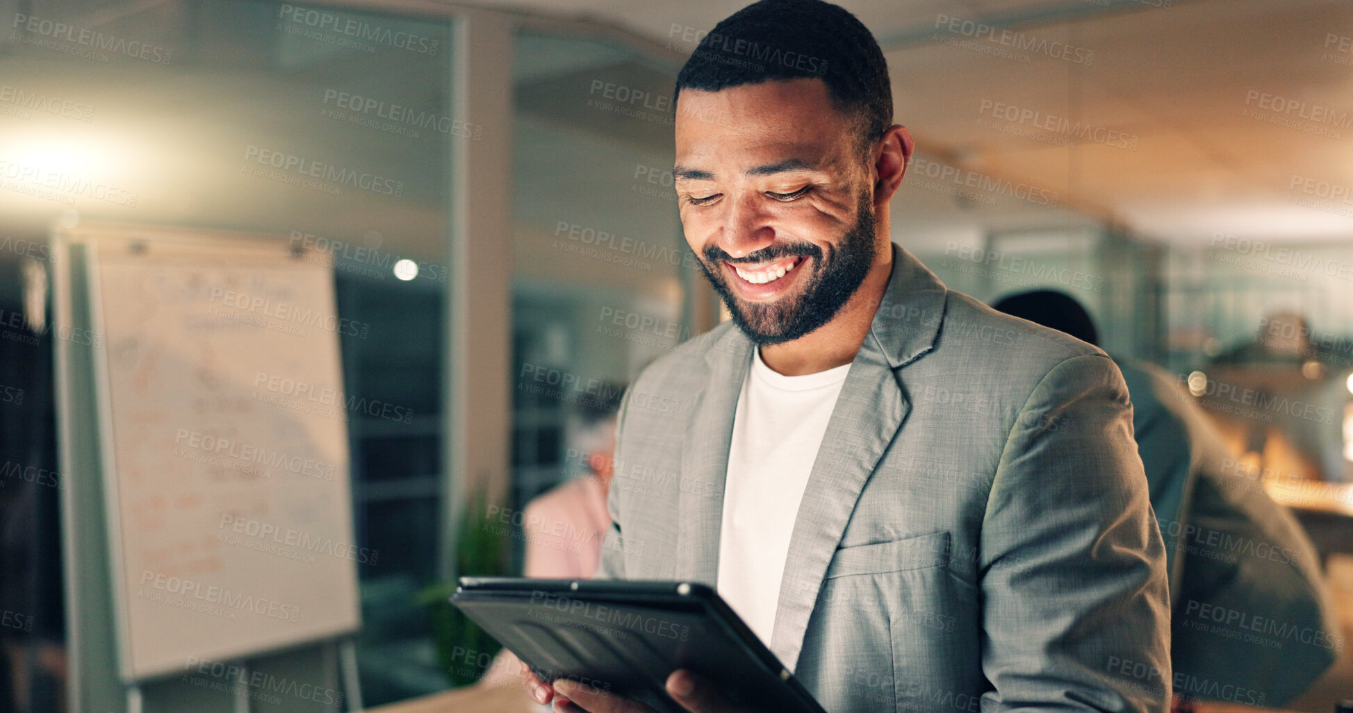 Buy stock photo Tablet, meeting and happy business man in office, working on research project, schedule and planning. Night, corporate and worker on digital tech laugh for internet, website review and social media