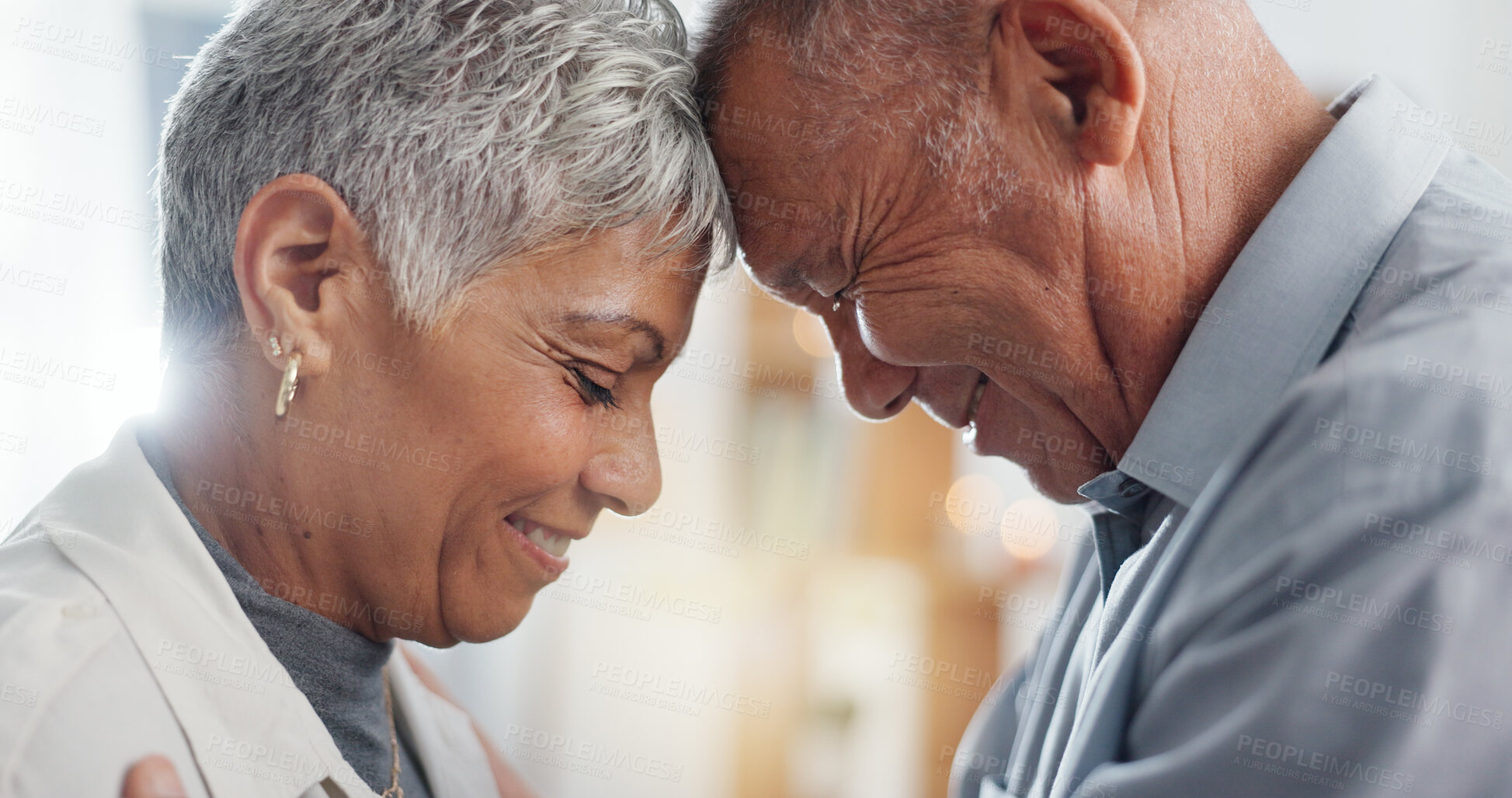 Buy stock photo Love, hug and senior couple in their home for support, happy together and affection with laugh or smile. Elderly woman and man with eyes closed for prayer in marriage, mindfulness and romance or care