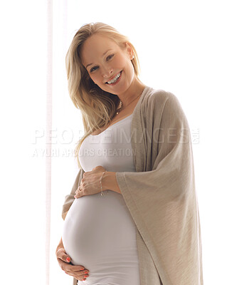Buy stock photo Cropped portrait of an attractive young pregnant woman holding her belly while standing in her  home