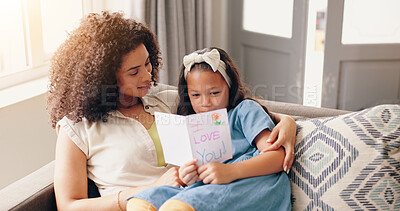 Mom, daughter and hug with mothers day card on sofa, smile and love with surprise from child in home. Heart, gift giving and embrace, happy holiday celebration with woman and kid on couch with care.