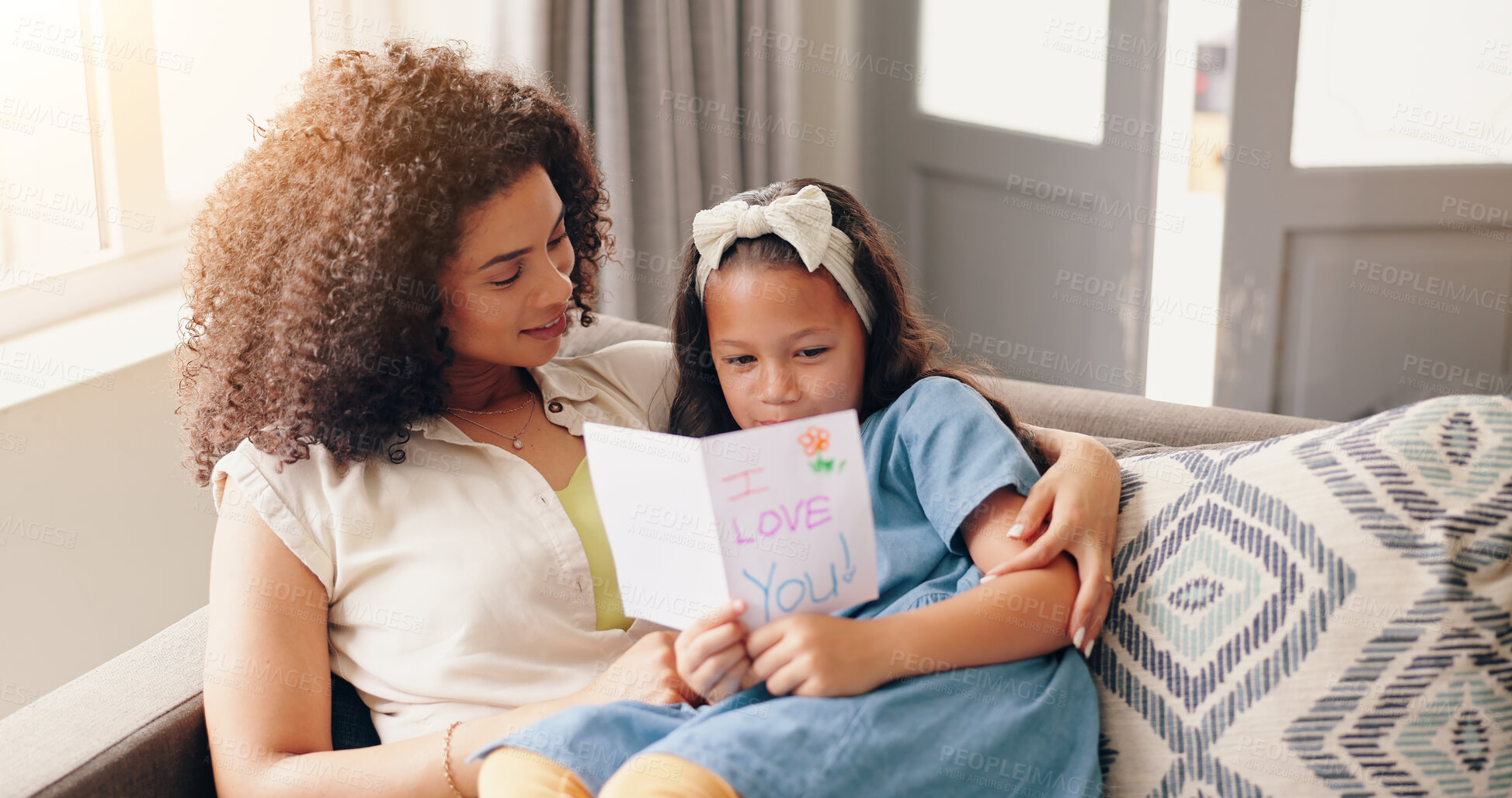 Buy stock photo Mom, daughter and hug with mothers day card on sofa, smile and love with surprise from child in home. Heart, gift giving and embrace, happy holiday celebration with woman and kid on couch with care.