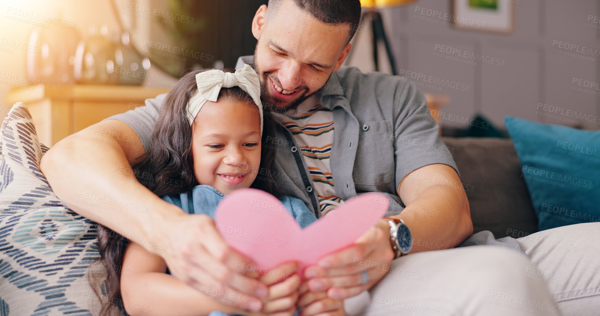 Buy stock photo Dad, daughter and fathers day card on sofa with smile, love and fun surprise from child in home. Heart, gift and giving, happy holiday celebration with man and kid on couch in living room with care.