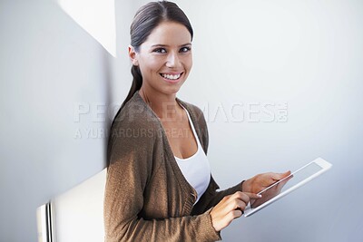 Buy stock photo A gorgeous young woman using her digital tablet in the office