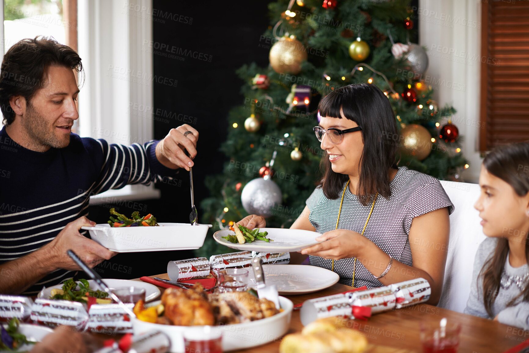 Buy stock photo Christmas, family and parents with child in home for dinner, lunch and eating together for festival. Mother, father and girl with food for holiday, vacation and festive celebration at dining table