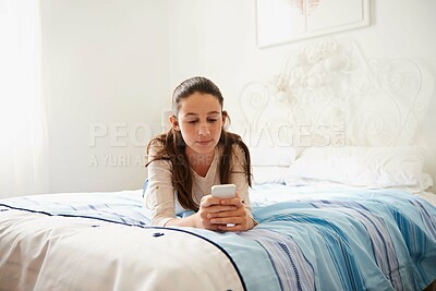 Buy stock photo Bed, teenager and girl with phone, chat or texting on social media, digital and app on mobile. Bedroom, kid and female person with technology to relax, connect and communication with internet online