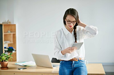 Buy stock photo Cropped shot of an attractive young businesswoman using a digital tablet in the office. The commercial designs displayed represent a simulation of a real product and have been changed or altered enough by our team of retouching and design specialists so that they don't have copyright infringements