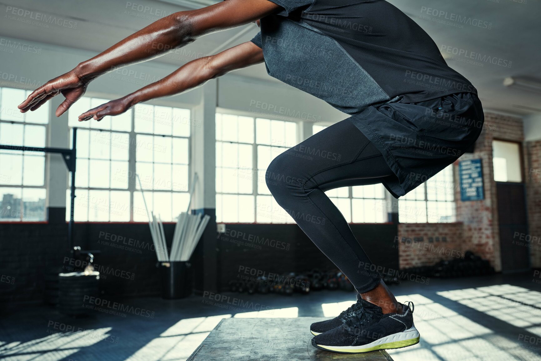 Buy stock photo Shot of an unrecognizable man doing jumping exercises on a wooden block in a gym