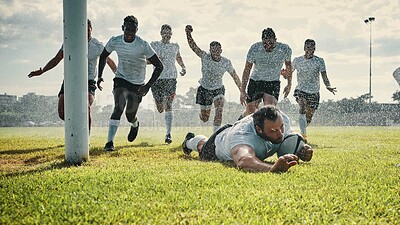 Buy stock photo Full length shot of a handsome young rugby player scoring a try while training on a rainy day