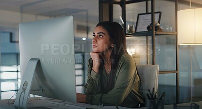 Buy stock photo Shot of a young businesswoman looking thoughtful while working on a computer in an office at night