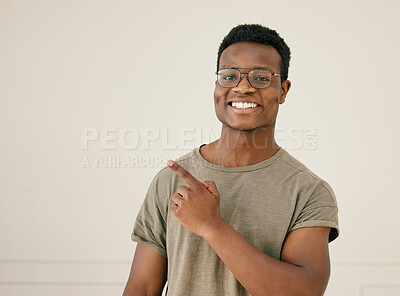 Buy stock photo Pointing, portrait and smile of black man with white background in studio for announcement or promotion. Glasses, marketing and mockup with happy person showing information, news or notification