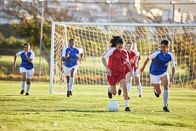 Buy stock photo Sports team, girl soccer and kick ball on field in a tournament. Football, competition and athletic female teen group play game on grass. Fit adolescents compete to win match at school championship.