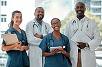 Group of doctors and nurses standing in a line with their arms crossed while working at a hospital. Content expert medical professionals smiling at work together at a clinic