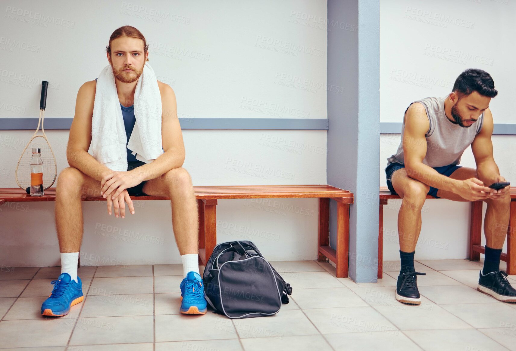 Buy stock photo Portrait of a caucasian athlete sitting in a locker room. Two men sitting in a gym locker room together. Serious player relaxing in a gym together. Professional players resting together