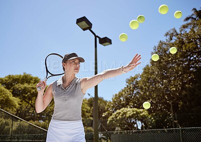 Buy stock photo Tennis, tennis ball and woman serving for fitness training, cardio workout and sports exercise outdoors in summer. Focus, action and healthy athlete serves multiple balls on a tennis court in a game