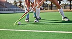 Hockey, field and athletes playing a game at a championship or sports training at an outdoor stadium. Fitness, action and team with sticks and a ball doing a exercise or skill on a sport turf court.