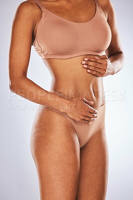 Buy stock photo Stomach, wellness and woman in studio for diet, weight loss and detox against a grey background. Hands, belly and girl model feeling results of liposuction, tummy tuck or cosmetic treatment isolated