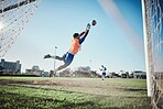 Fitness, goalkeeper or soccer player taking a penalty in a game or training match at a tournament. Save, back or male football athlete kicking ball at practice on outdoor field or pitch in stadium 