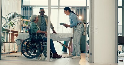 Healthcare, wheelchair and a nurse talking to an old couple in the hospital for insurance or admission. Medical, senior woman with a disability and a medicine professional in discussion of treatment