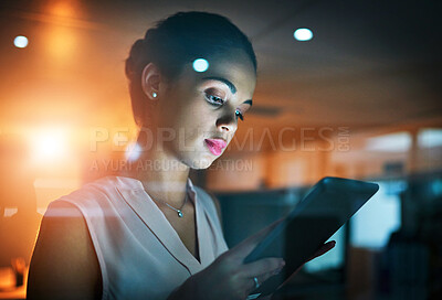 Buy stock photo Shot of a young businesswoman using a tablet in the office at night 