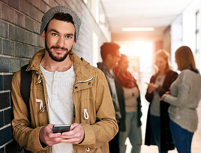 Buy stock photo Portrait of a young male university student standing in a campus corridor with his classmates in the background